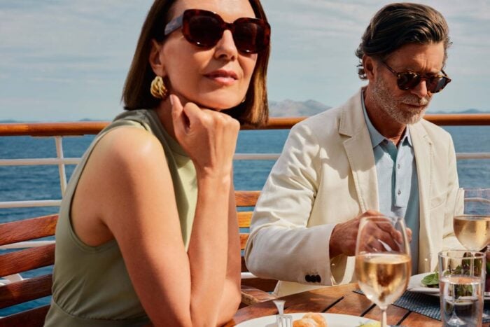 Couple dining on deck with wine aboard a Crystal cruise