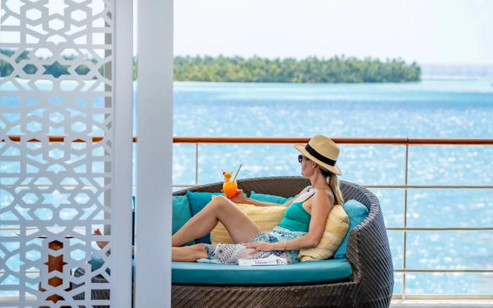Guest relaxing on the pool deck of the m/s Paul Gauguin off Tahaa
