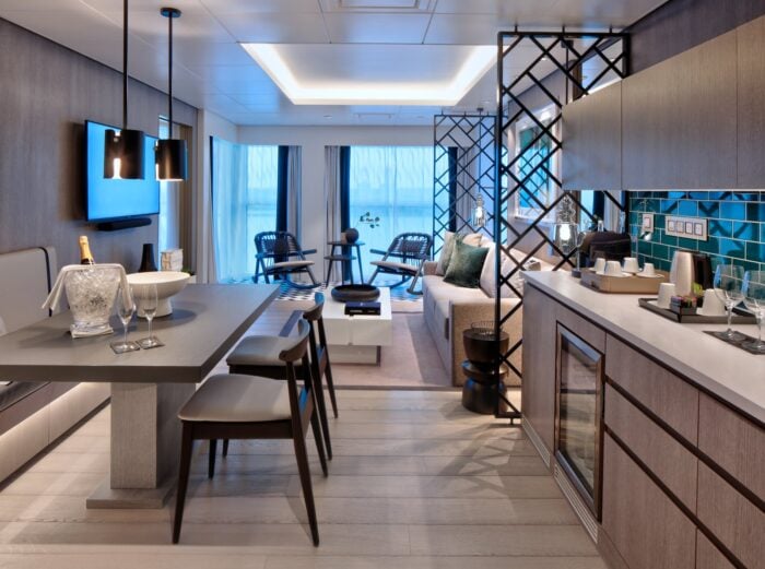 Spacious Celebrity Edge-class suite with dining table, living area and balcony
