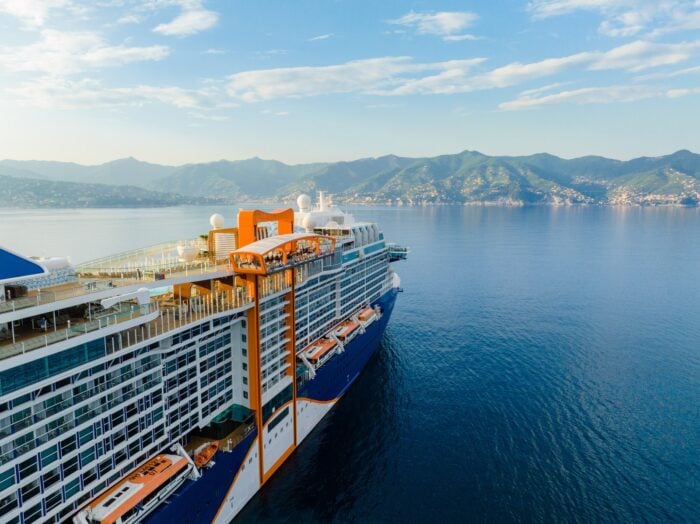 Celebrity Edge-class cruise ship with its orange Magic Carpet platform sailing along the Italian Riviera on a Europe cruise