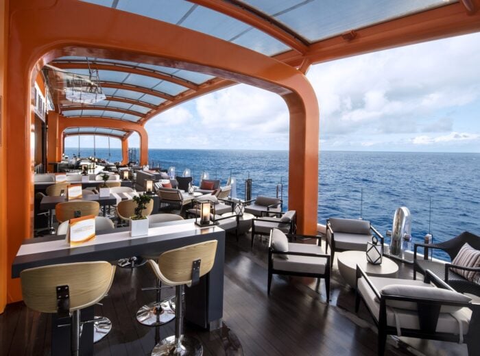 The Magic Carpet open-air lounge suspended over the sea on a Celebrity Edge-class ship