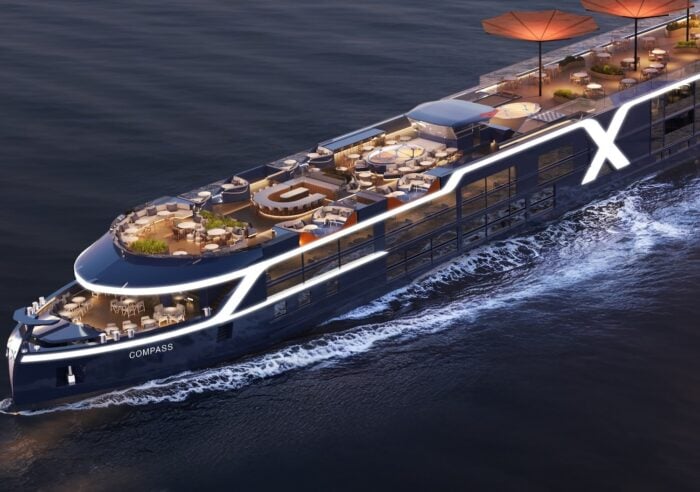 Celebrity Compass, one of the new Celebrity River Cruises ships, sailing at dusk with its lit top deck