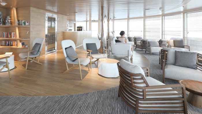 Panoramic observation lounge with white armchairs aboard PONANT's Le Laperouse
