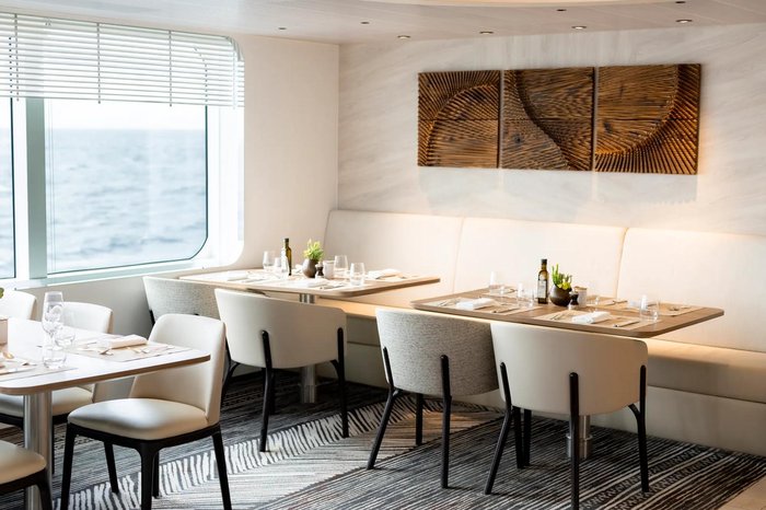 Sunlit gourmet restaurant aboard PONANT's Le Dumont d'Urville