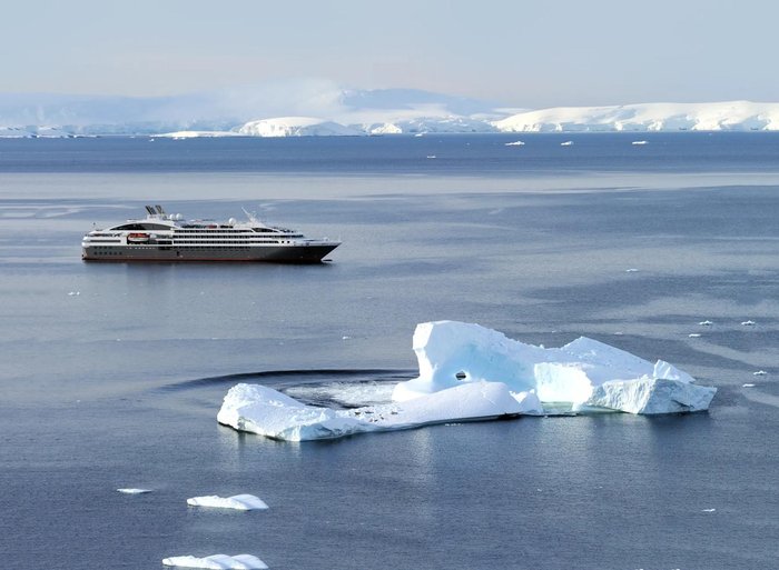 Ponant military discount cruise: Le Boreal sailing past an iceberg in Antarctica
