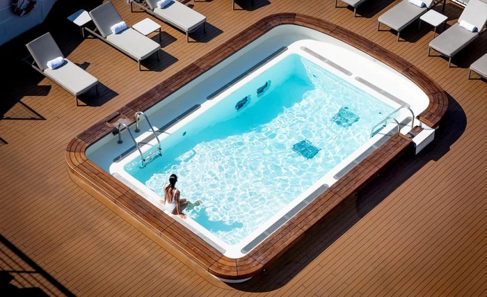 Aerial view of the turquoise pool and teak sun deck on PONANT's L'Austral in the Greek Islands